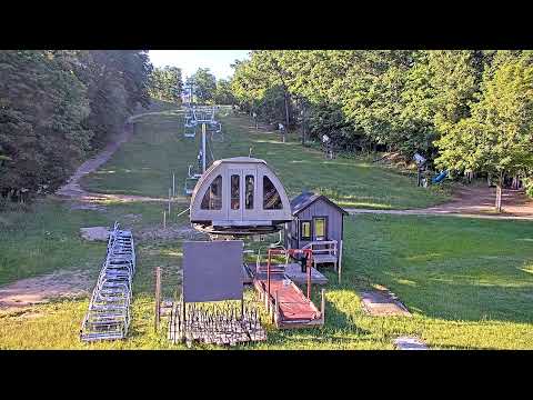 Scenic view from Arlo’s Deck live webcam at Caberfae Peaks Michigan showing ski slopes and forested hills