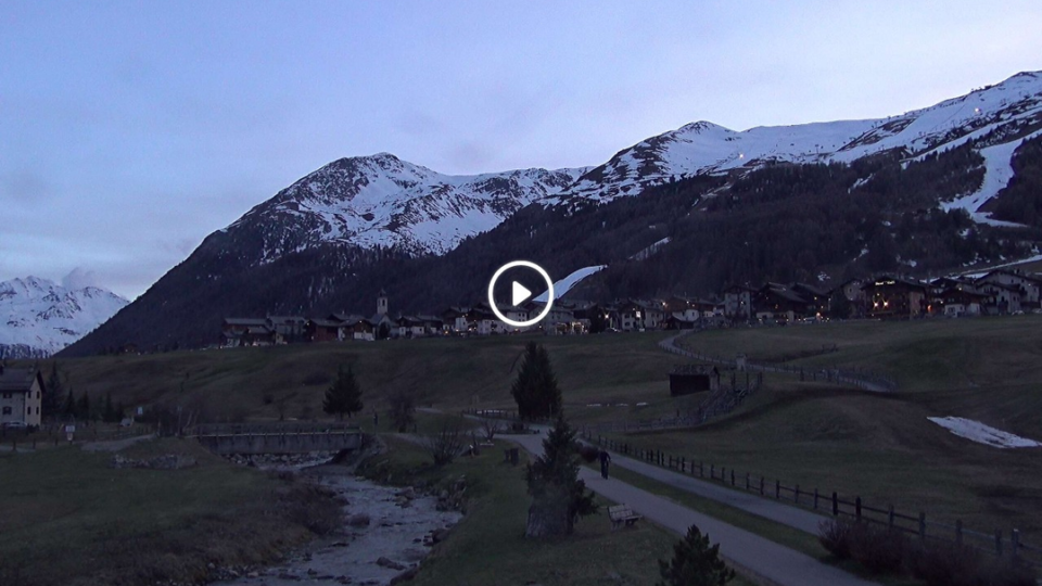 Live webcam view of the Pista Ciclabile bicycle path in Livigno, Italy, surrounded by snow-capped alpine mountains at 1835m altitude
